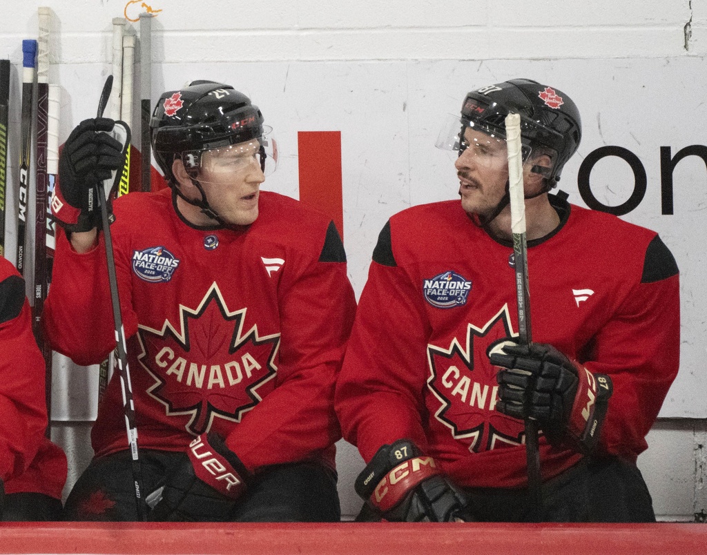 FILE - Canada players, Nathan MacKinnon and Sidney Crosby talk on the bench during 4 Nations Face-Off hockey practice in Brossard, Quebec on Feb. 10, 2025. (Christinne Muschi/The Canadian Press via AP, File)