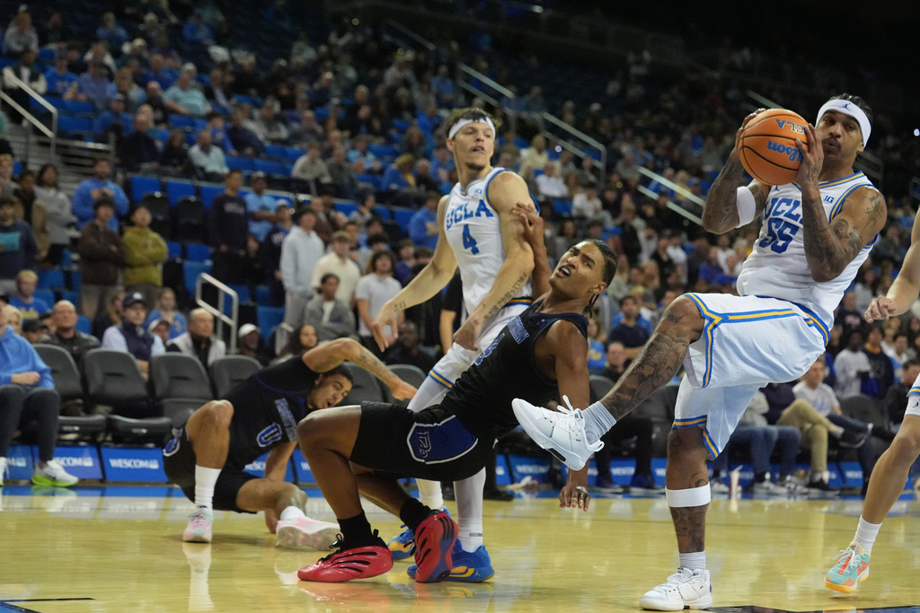 UCLA guard Skyy Clark (55) steals the ball against Presbyterian guard Josh Pickett (4) during the first half of an NCAA college basketball game in Los Angeles, Friday, Nov.21, 2025. (AP Photo/Damian Dovarganes)
