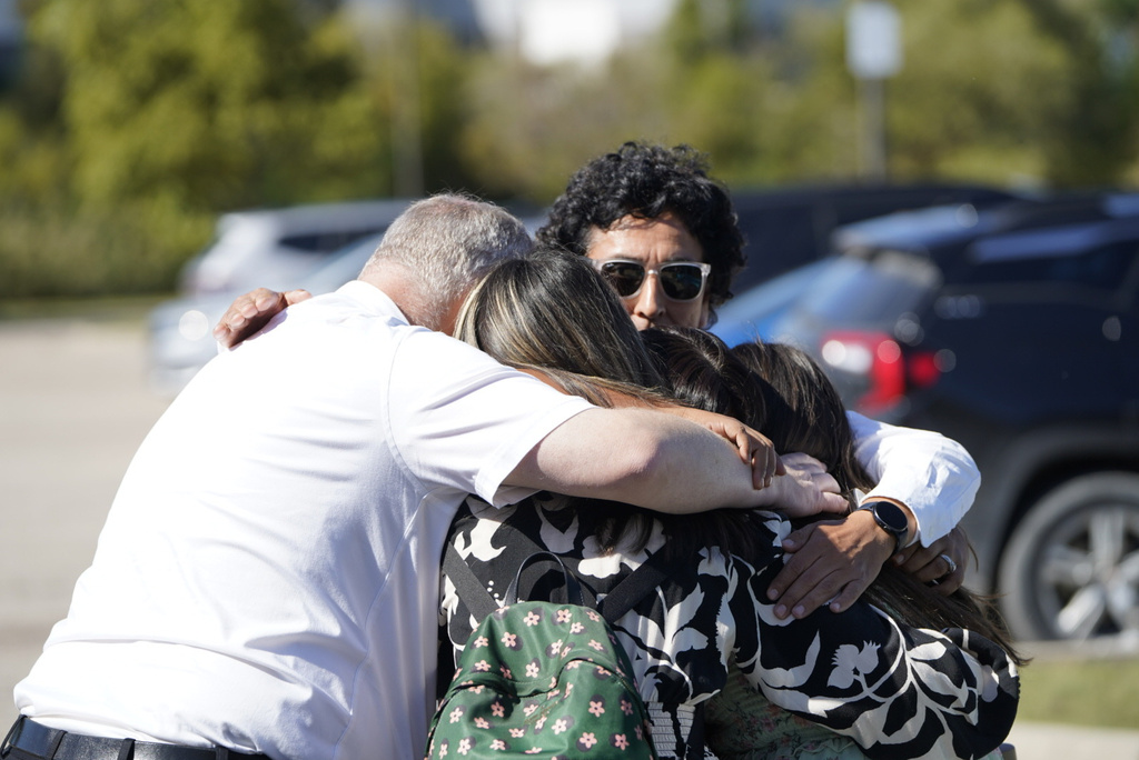 People meet at a reunification area at the Trillium Theater after an active shooter incident and fire at The Church of Jesus Christ of Latter-day Saints in Grand Blanc, Mich on Sunday, Sept. 28, 2025. (Lukas Katilius/The Flint Journal via AP)