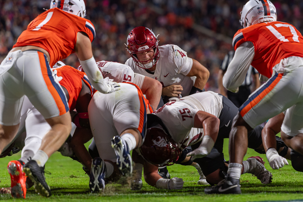 Washington State quarterback Zevi Eckhaus (4) goes over the top for a first down against Virginia during the first half of an NCAA college football game, Saturday, Oct. 18 2025, in Charlottesville, Va. (AP Photo/Robert Simmons)