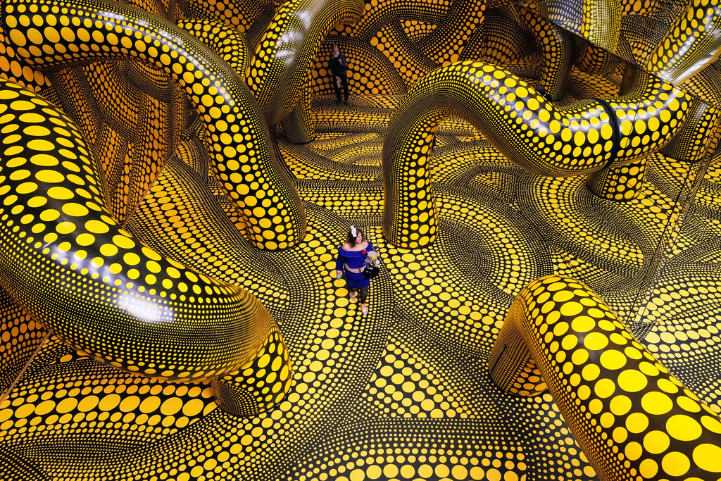 People walk through the artwork 'Infinity Mirrored Room' during a preview of the new major exhibition of legendary Japanese artist Yayoi Kusama at the Museum Ludwig in Cologne, Thursday, March 12, 2026. (AP Photo/Martin Meissner)