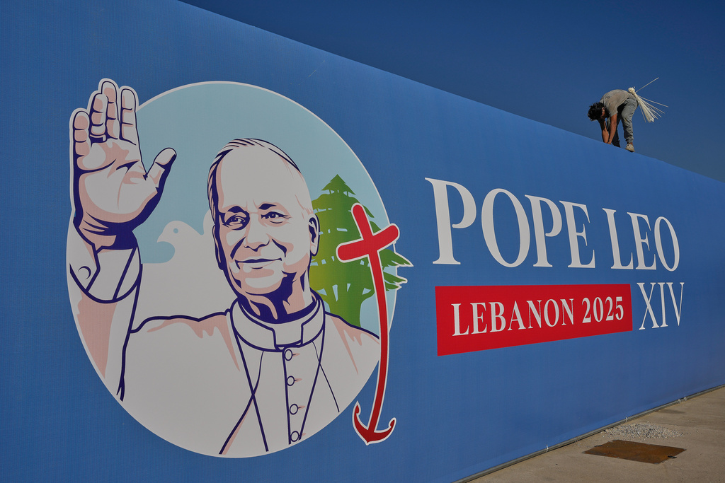 A worker sets a billboard displays an image of Pope Leo XIV in preparation of the area where he will holds a Holy mass during his visit to Lebanon, at the waterfront of downtown Beirut, Thursday, Nov. 27, 2025. (AP Photo/Hussein Malla)
