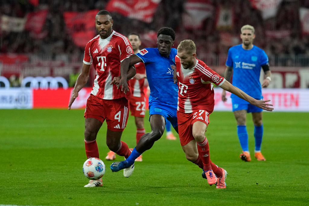 Bayern's Konrad Laimer is challenged by Leverkusen's Ernest Poku, rear, during the German Bundesliga soccer match between Bayern Munich and Bayern Leverkusen in Munich, Germany, Saturday, Nov. 1, 2025. (AP Photo/Matthias Schrader)