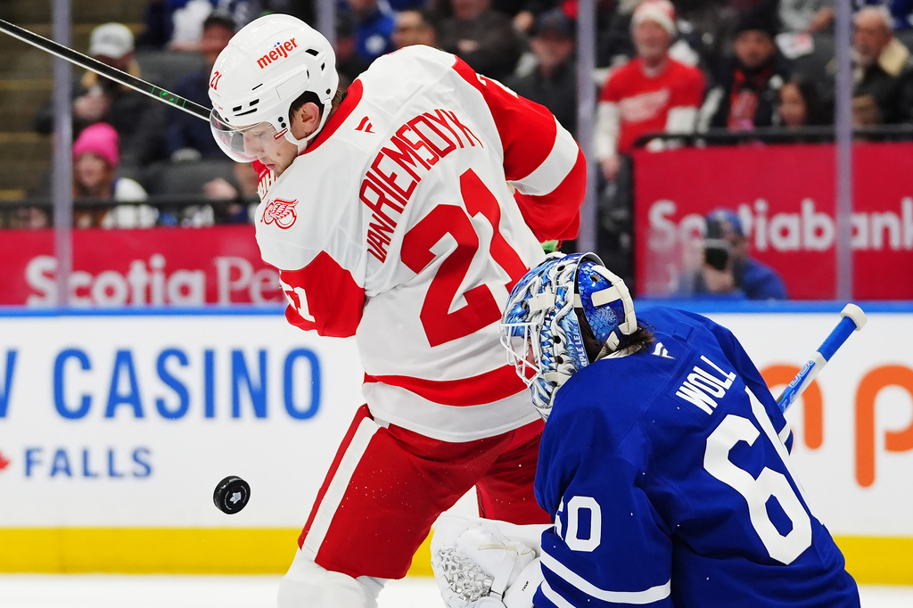 Toronto Maple Leafs goaltender Joseph Woll (60) makes a save as Detroit Red Wings' James van Riemsdyk (21) looks for the rebound during the first period of an NHL hockey game in Toronto, Wednesday, Jan. 21, 2026. (Frank Gunn/The Canadian Press via AP)