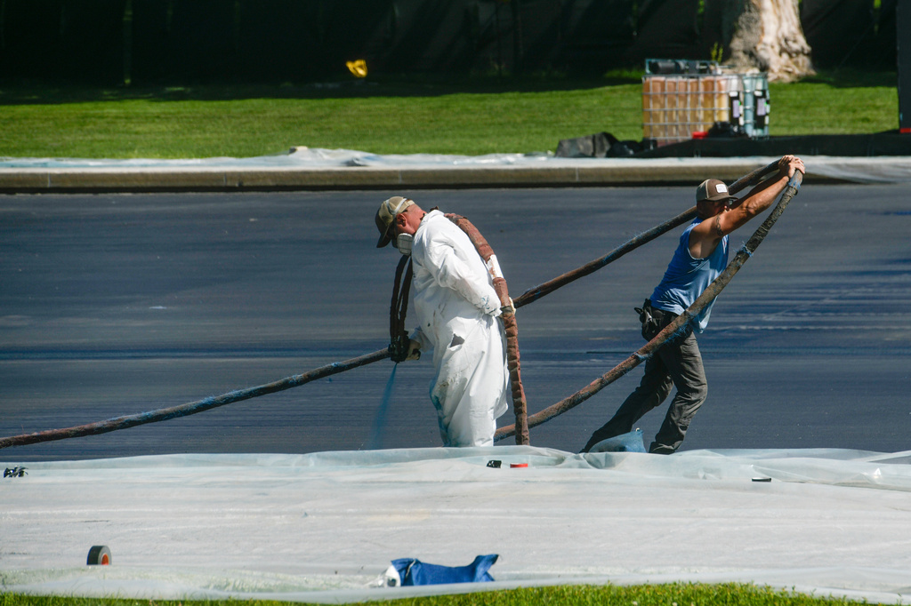 Work continues on the Lincoln Memorial Reflecting Pool, which is covered in a blue coating, ahead of the United States 250th anniversary, Thursday, June 4, 2026, in Washington. (AP Photo/Rod Lamkey, Jr.)