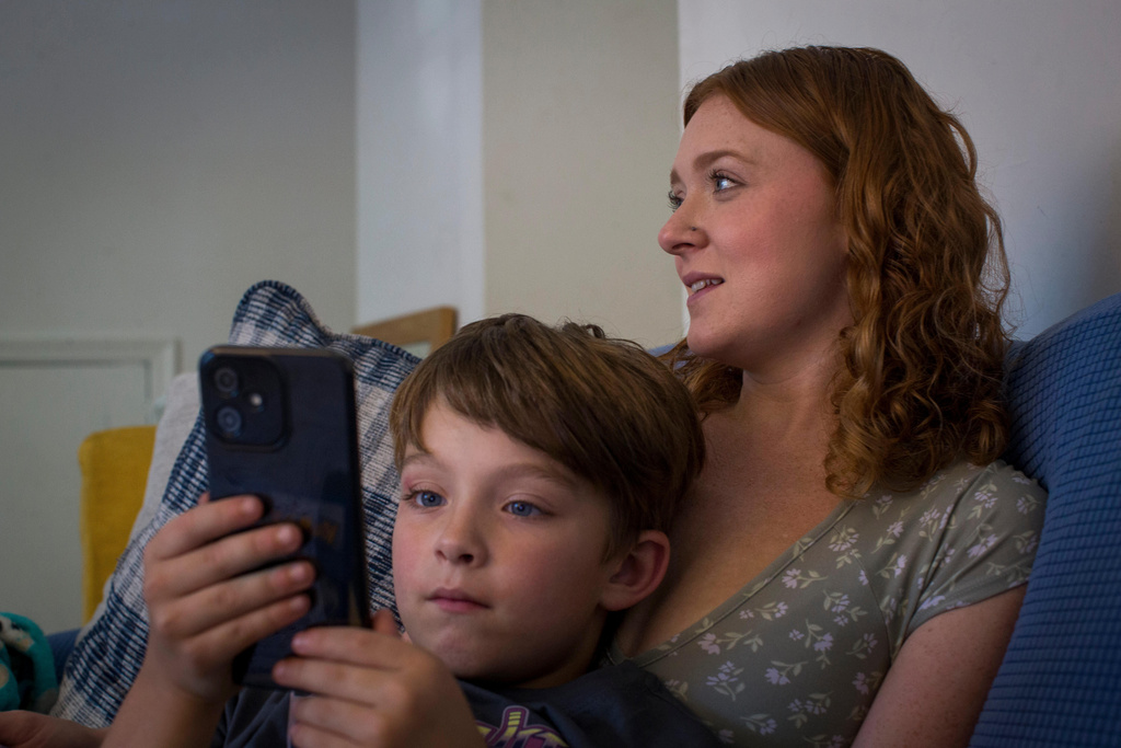 Taylor Moyer watches TV with her oldest son Liam at home, Sunday, Oct. 5, 2025, in Virginia Beach, Va. (AP Photo/John Clark)