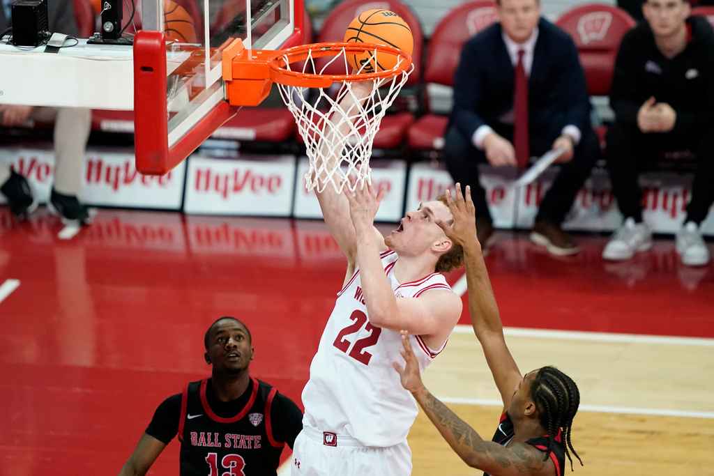 Wisconsin forward Austin Rapp (22) scores against Ball State guard Devon Barnes (13) and Ball State guard Armoni Zeigler during the first half of an NCAA college basketball game Tuesday, Nov. 11, 2025, in Madison, Wis. (AP Photo/Kayla Wolf)