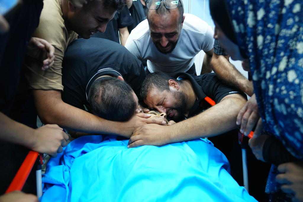 Relatives of Palestinian Karim Shalaldeh, 17, cry over his body at a hospital in the West Bank city of Hebron, Friday, Aug. 21, 2026. (AP Photo/Mahmoud Illean)