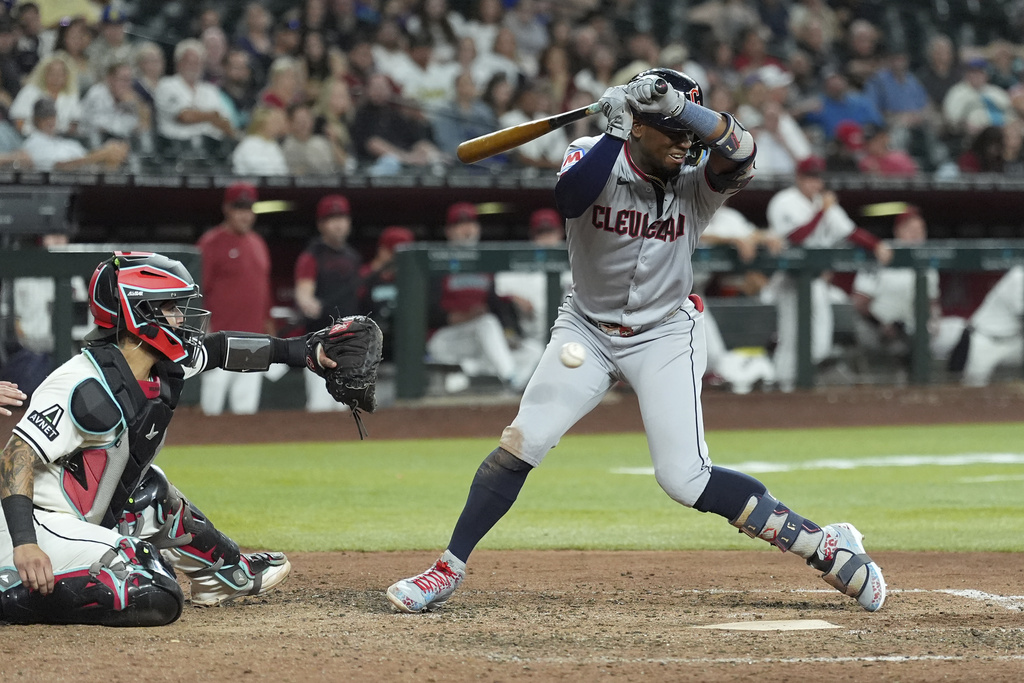 Cleveland Guardians' Angel Martínez, right, backs off an inside pitch as Arizona Diamondbacks catcher Jose Herrera, left, reaches for the ball during the eighth inning of a baseball game Tuesday, Aug. 19, 2025, in Phoenix. (AP Photo/Ross D. Franklin)