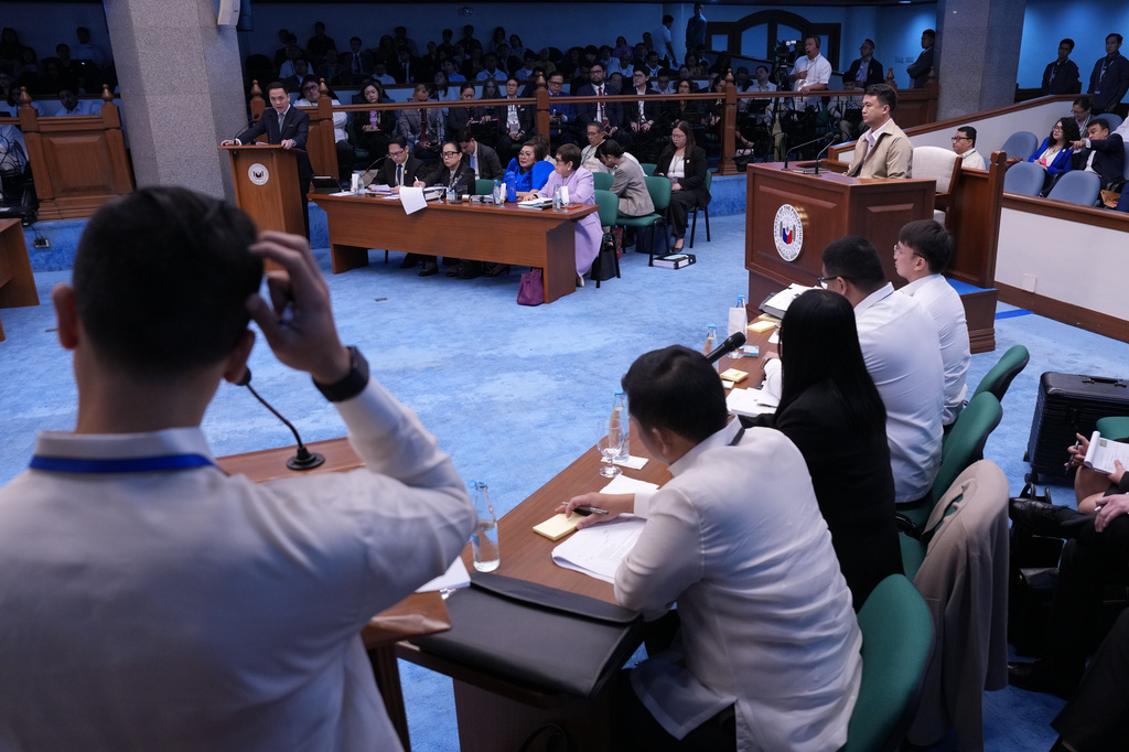 National Bureau of Investigation senior agent John Mark Calilung, right, listens as prosecutor and defense teams speak during the impeachment trial of Philippine Vice President Sara Duterte at the Philippine Senate in Pasay city, Philippines on Tuesday, July 7, 2026. (AP Photo/Aaron Favila, Pool)