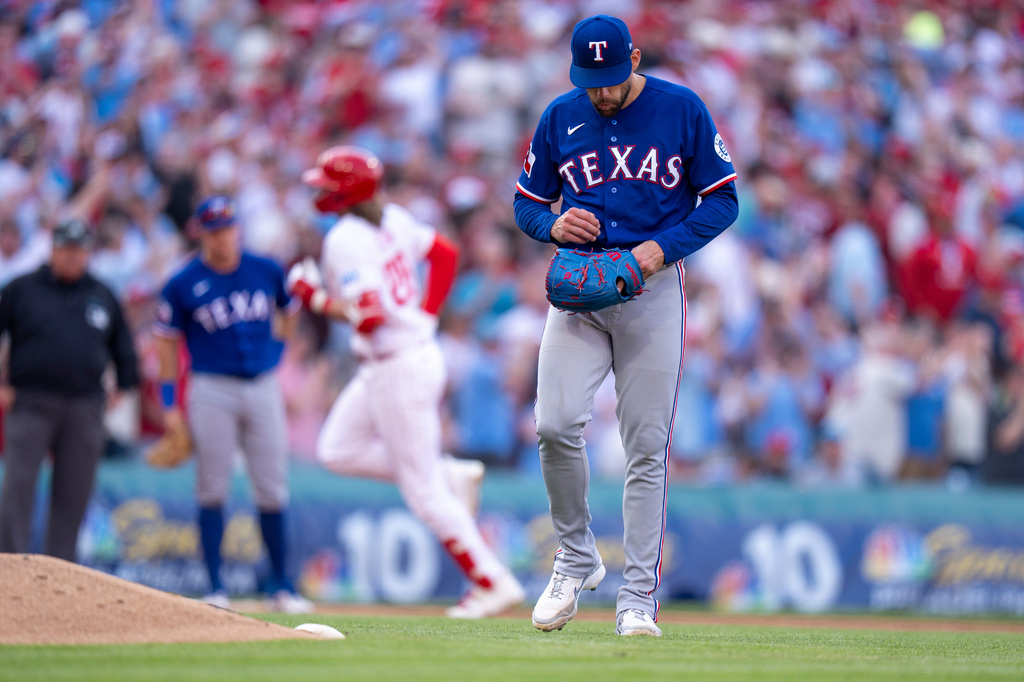 Texas Rangers stating pitcher Nathan Eovaldi, right, reacts to giving up a three-run home run to Philadelphia Phillies' Alec Bohm, left, during the fifth inning of an opening-day baseball game, Thursday, March 26, 2026, in Philadelphia. (AP Photo/Chris Szagola)