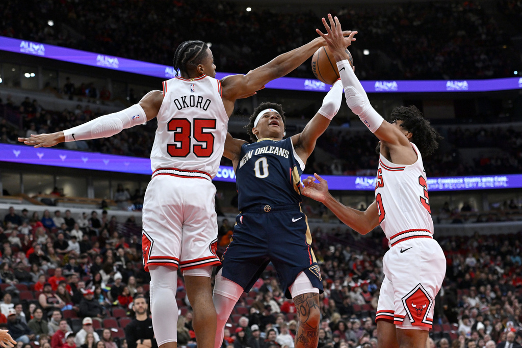 New Orleans Pelicans' Jeremiah Fears (0) goes up for a shot against Chicago Bulls' Isaac Okoro (35) and Tre Jones (30) during the first half of an NBA basketball game, Wednesday, Dec. 31, 2025, in Chicago. (AP Photo/Paul Beaty)