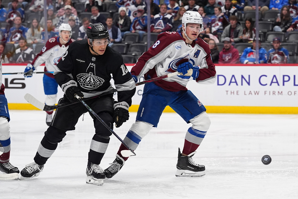 Los Angeles Kings left wing Trevor Moore, left, and Colorado Avalanche defenseman Cale Makar pursue the puck in the second period of an NHL hockey game Monday, Dec. 29, 2025, in Denver. (AP Photo/David Zalubowski)