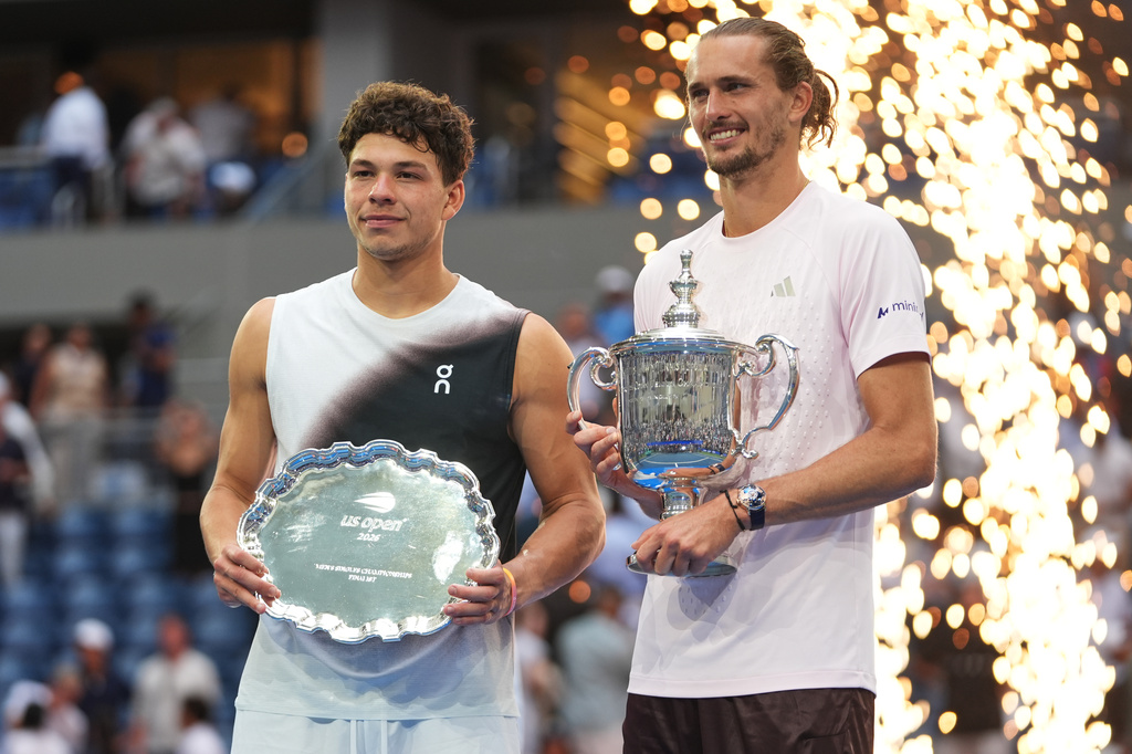 Ben Shelton, of the United States, left, and Alexander Zverev, of Germany, right, pose for a photo together with their trophies after Zverev won the men's singles final of the U.S. Open tennis championships Sunday, Sept. 13, 2026, in New York. (AP Photo/Frank Franklin II)