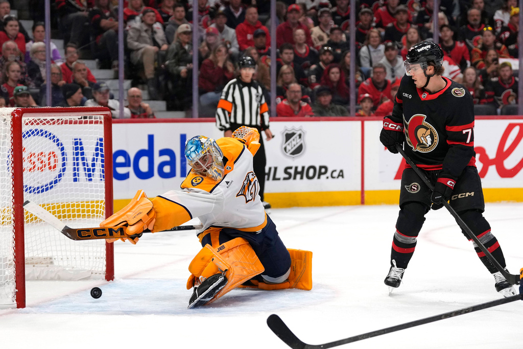 Nashville Predators goaltender Juuse Saros makes a save in front of Ottawa Senators' Ridly Greig during the second period of an NHL hockey game in Ottawa, Ontario, on Monday, Oct. 13, 2025. (Justin Tang/The Canadian Press via AP)