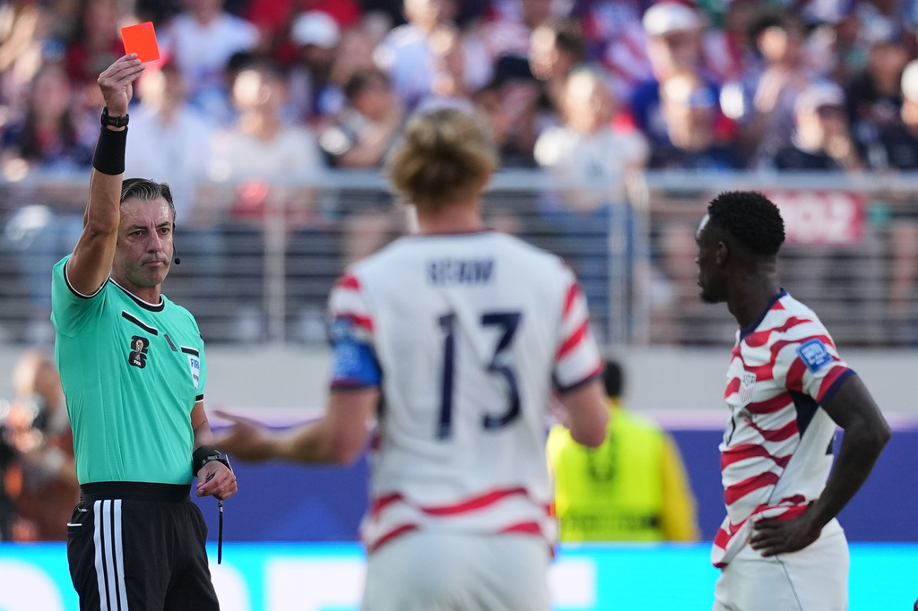 Referee Raphael Claus of Brazil shows a red card to United States' Folarin Balogun, right, during the World Cup round of 32 soccer match between the United States and Bosnia in Santa Clara, Calif., near San Francisco, Wednesday, July 1, 2026. (AP Photo/Julio Cortez)