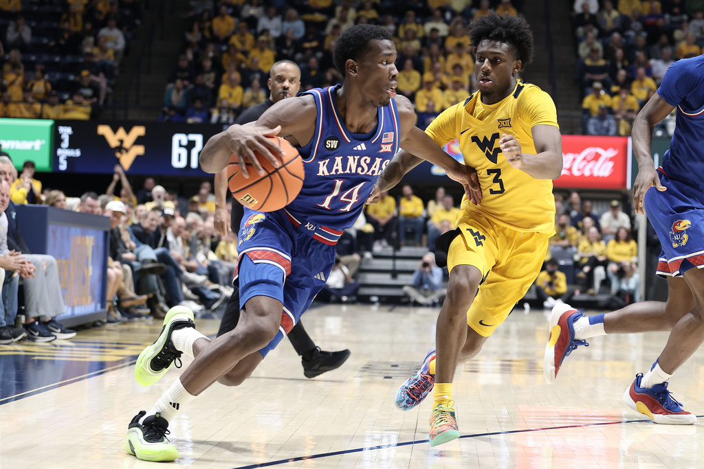 Kansas guard Melvin Council Jr. (14) is defended by West Virginia guard Honor Huff (3) during the second half of an NCAA college basketball game Saturday, Jan. 10, 2026, in Morgantown, W.Va. (AP Photo/Kathleen Batten)