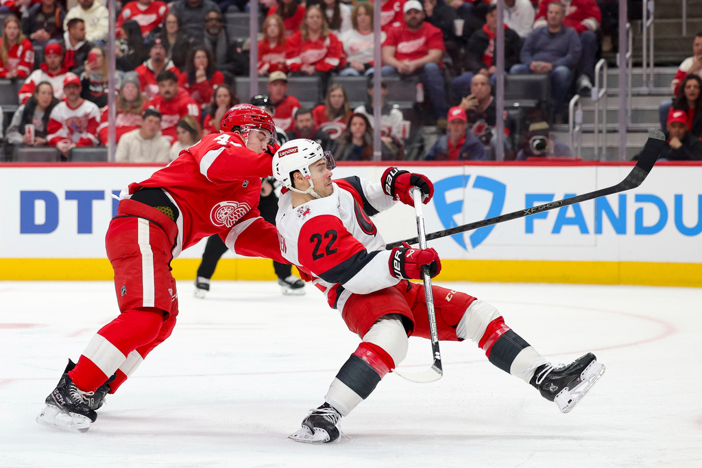 Detroit Red Wings defenseman Axel Sandin-Pellikka, left, and Carolina Hurricanes center Logan Stankoven collide during the first period of an NHL hockey game, Monday, Jan. 12, 2026, in Detroit. (AP Photo/Ryan Sun)