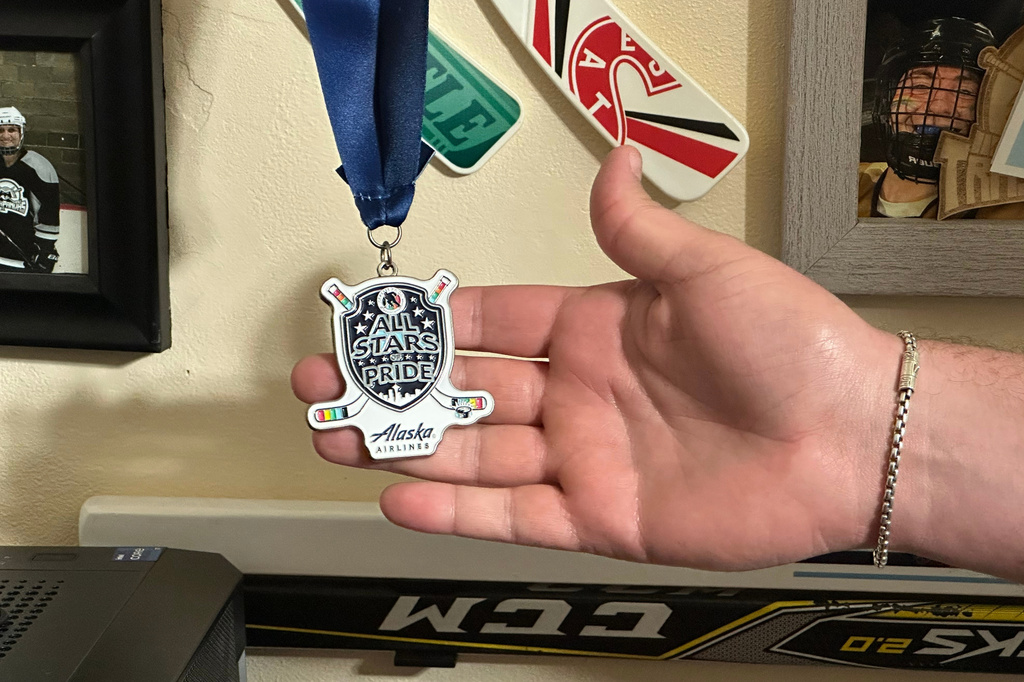 Steven Thompson, co-founder of the Seattle Pride Hockey Association (SPHA), sifts through some of his hockey memorabilia at his home in Des Moines, Wash., Monday, April 27, 2026. (AP Photo/Andrew Destin)