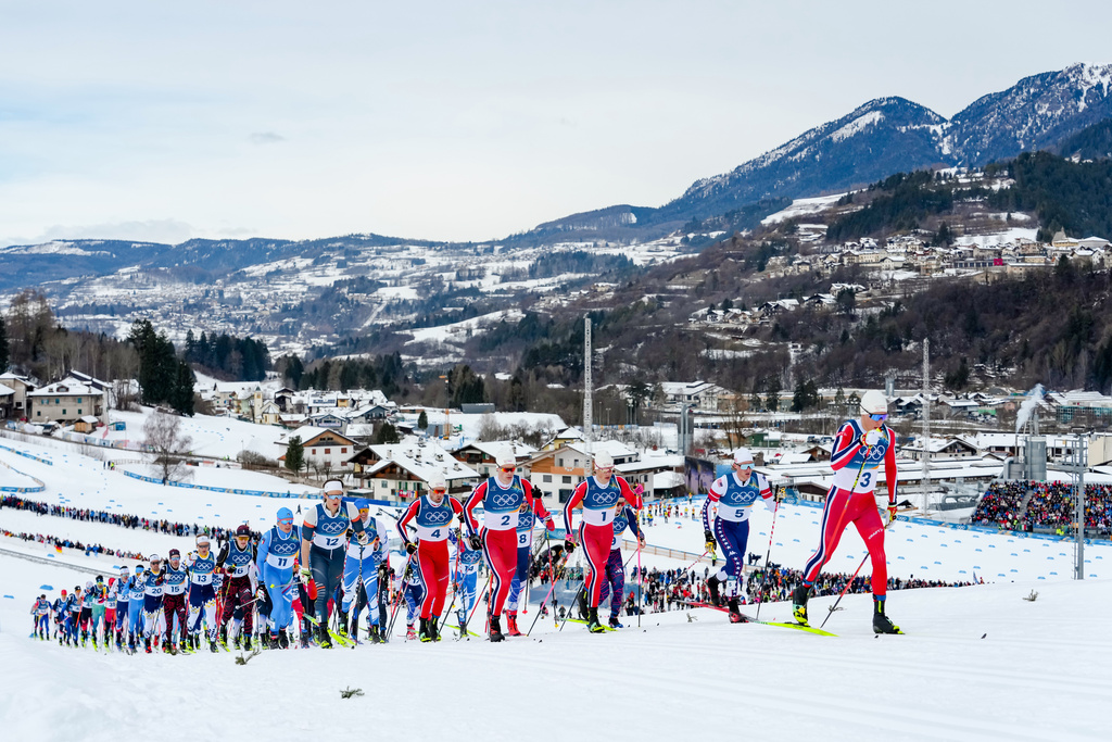 Martin Loewstroem Nyenget, of Norway, right, leads at the start of the cross country skiing men's 50km mass start Classic at the 2026 Winter Olympics, in Tesero, Italy, Saturday, Feb. 21, 2026. (AP Photo/Evgeniy Maloletka)