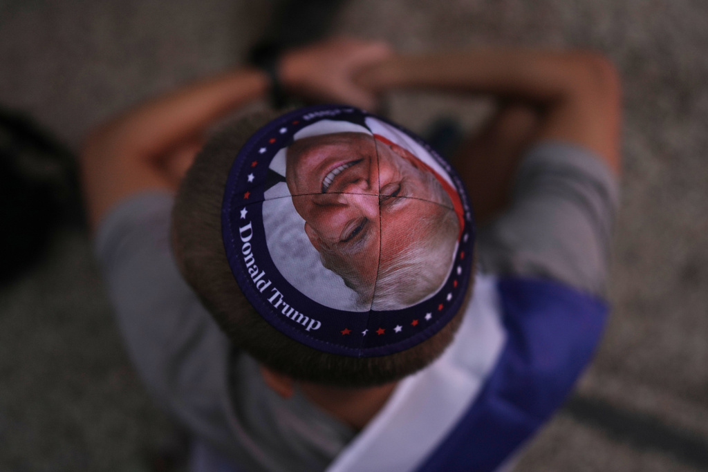 A Jewish man wears a kippah printed with the image of U.S. President Donald Trump during a gathering at a plaza known as hostages square in Tel Aviv, Israel, Monday, Oct. 13, 2025, before the release of Israeli hostages held in Gaza. (AP Photo/Oded Balilty)