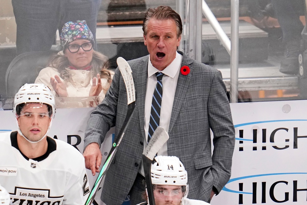 Los Angeles Kings head coach Jim Hiller, center top, gives directions during the third period of an NHL hockey game against the Pittsburgh Penguins in Pittsburgh, Sunday, Nov. 9, 2025. (AP Photo/Gene J. Puskar)