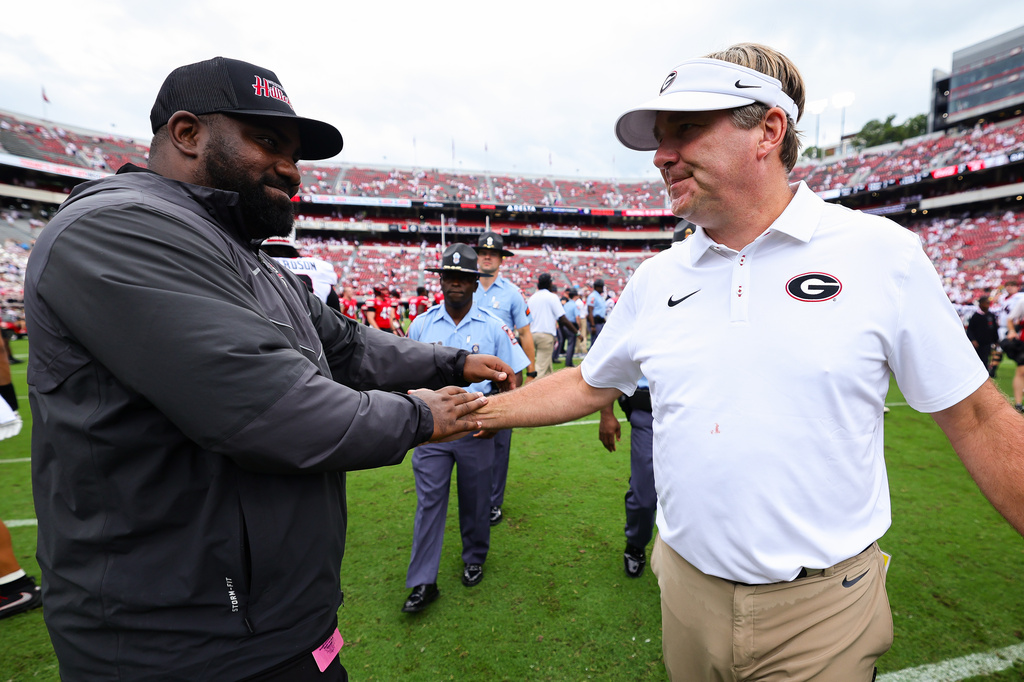 Western Kentucky assistant coach David Metcalf, left, embraces Georgia head coach Kirby Smart, right, after an NCAA college football game, Saturday, Sept. 12, 2026, in Athens, Ga. (AP Photo/Colin Hubbard)