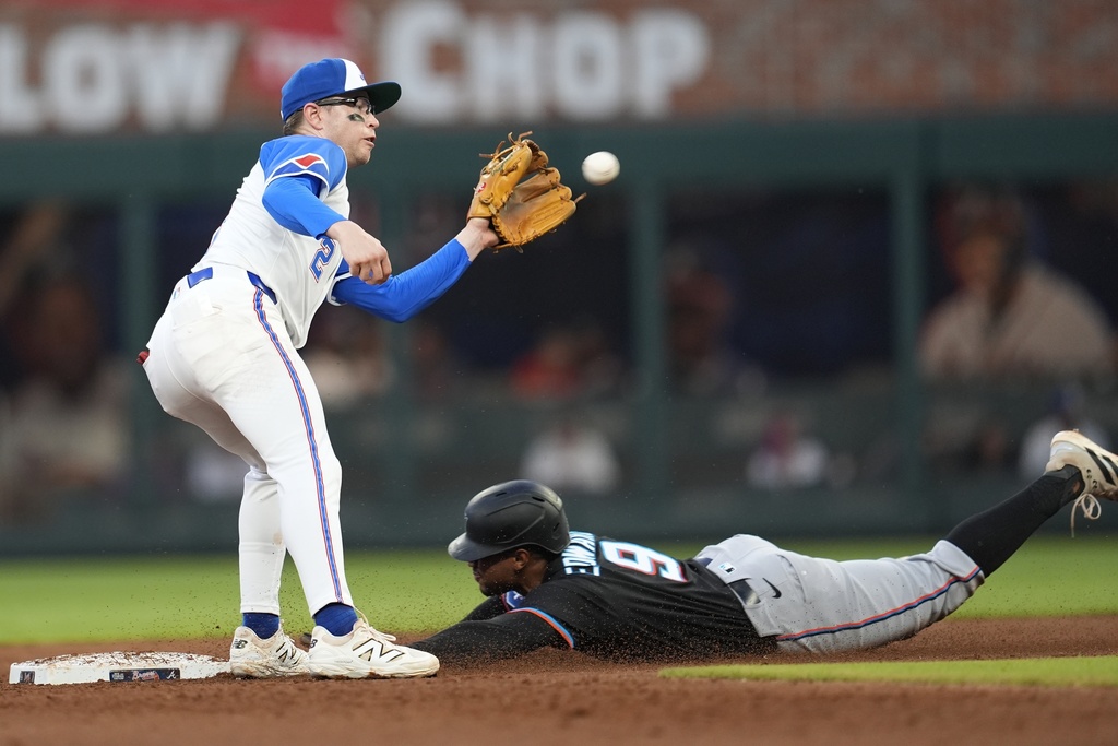 Miami Marlins' Xavier Edwards (9) slides safe into second base against Atlanta Braves shortstop Nick Allen (2) in the fourth inning in the second baseball game of a doubleheader, Saturday, Aug. 9, 2025, in Atlanta. (AP Photo/Mike Stewart)