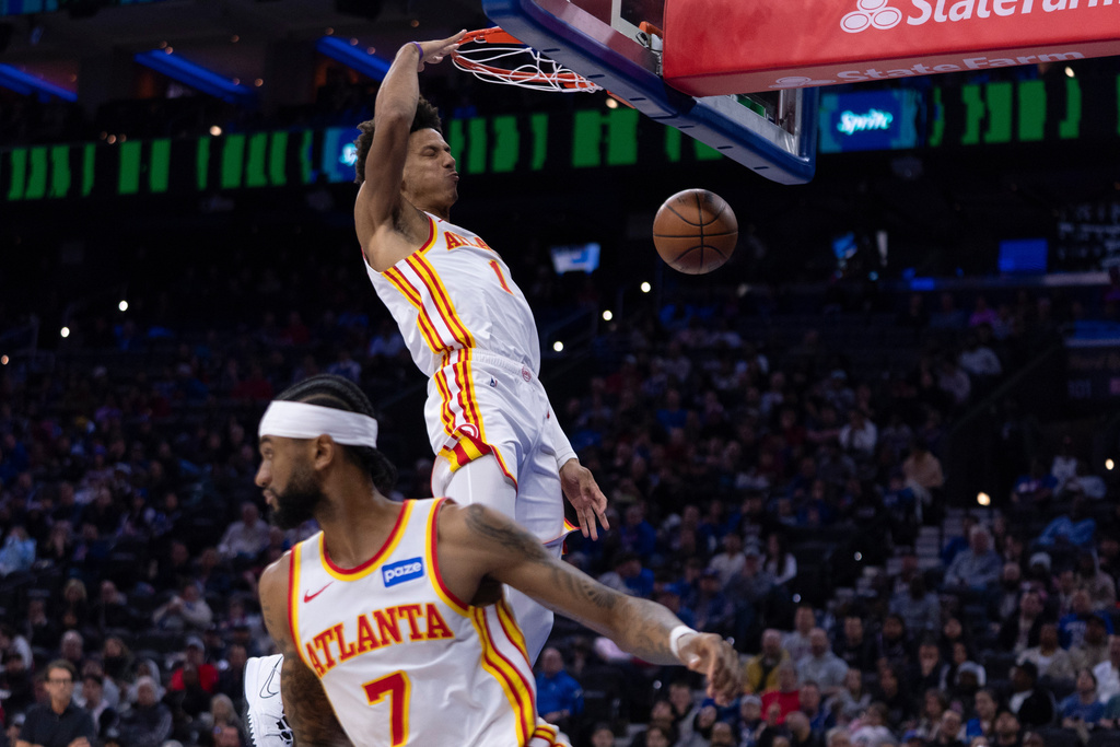 Atlanta Hawks' Jalen Johnson, right, dunks the ball from the pass by Nickeil Alexander-Walker, left, during the first half of an NBA basketball game against the Philadelphia 76ers, Sunday, Nov. 30, 2025, in Philadelphia. (AP Photo/Chris Szagola)