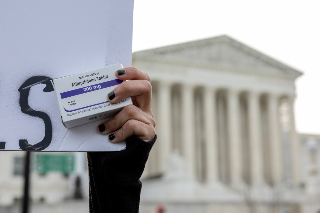 FILE - An abortion-rights activist holds a box of mifepristone pills as demonstrators from both anti-abortion and abortion-rights groups rally outside the Supreme Court in Washington, March 26, 2024. (AP Photo/Amanda Andrade-Rhoades, File)