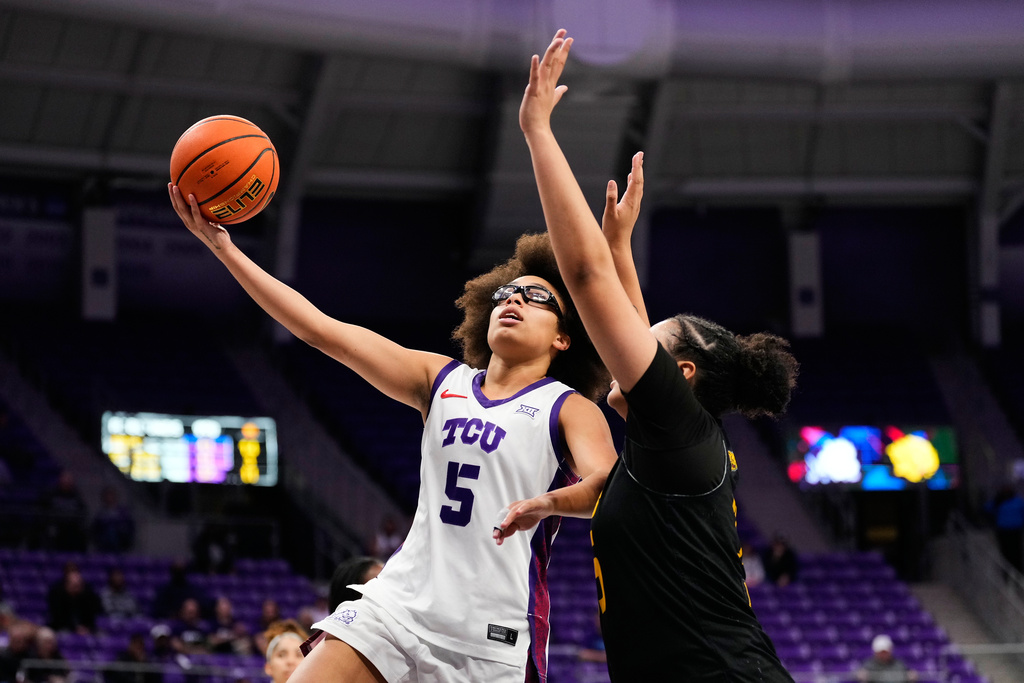 TCU guard Olivia Miles (5) leaps to the basket to shoot as Arkansas Pine Bluff forward Zoey Davis, right, defends in the second half of an NCAA women's basketball game in Fort Worth, Texas, Tuesday, Dec. 16, 2025. (AP Photo/Tony Gutierrez)