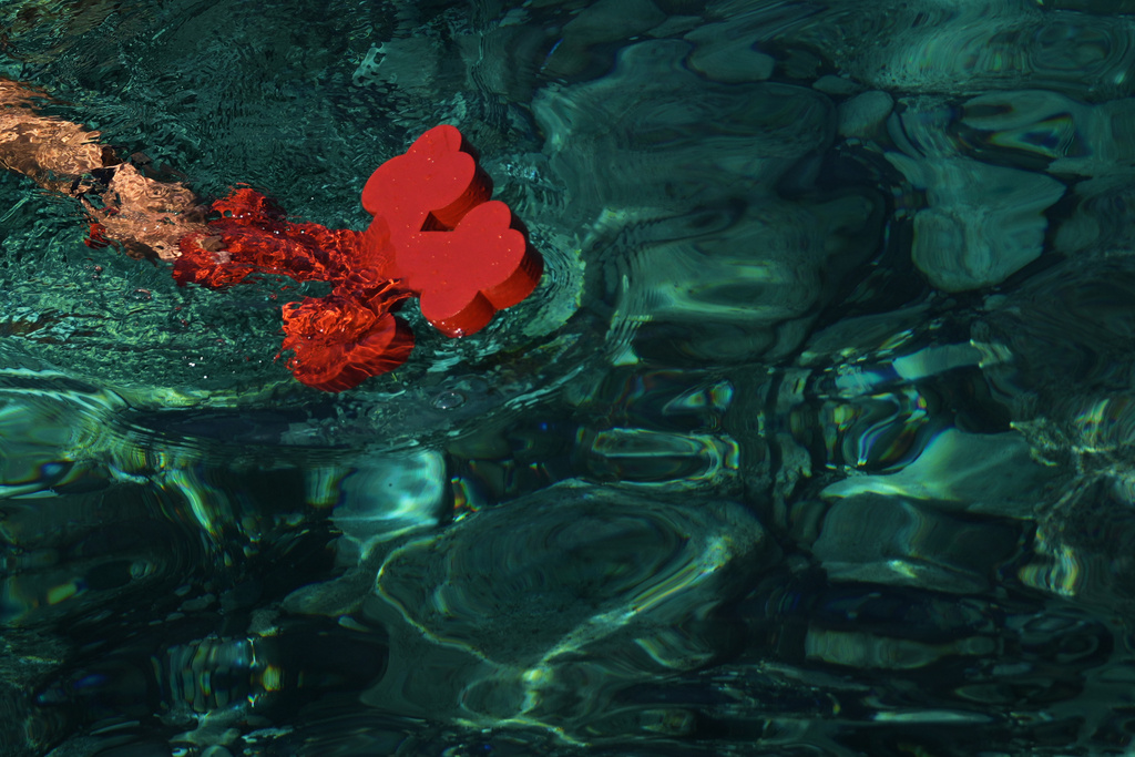 A pilgrim catches a cross after an Orthodox priest throw it into the water during an Epiphany ceremony to bless the sea in the southeastern village of Xylophagou, Cyprus, Tuesday, Jan. 6, 2026. (AP Photo/Petros Karadjias)