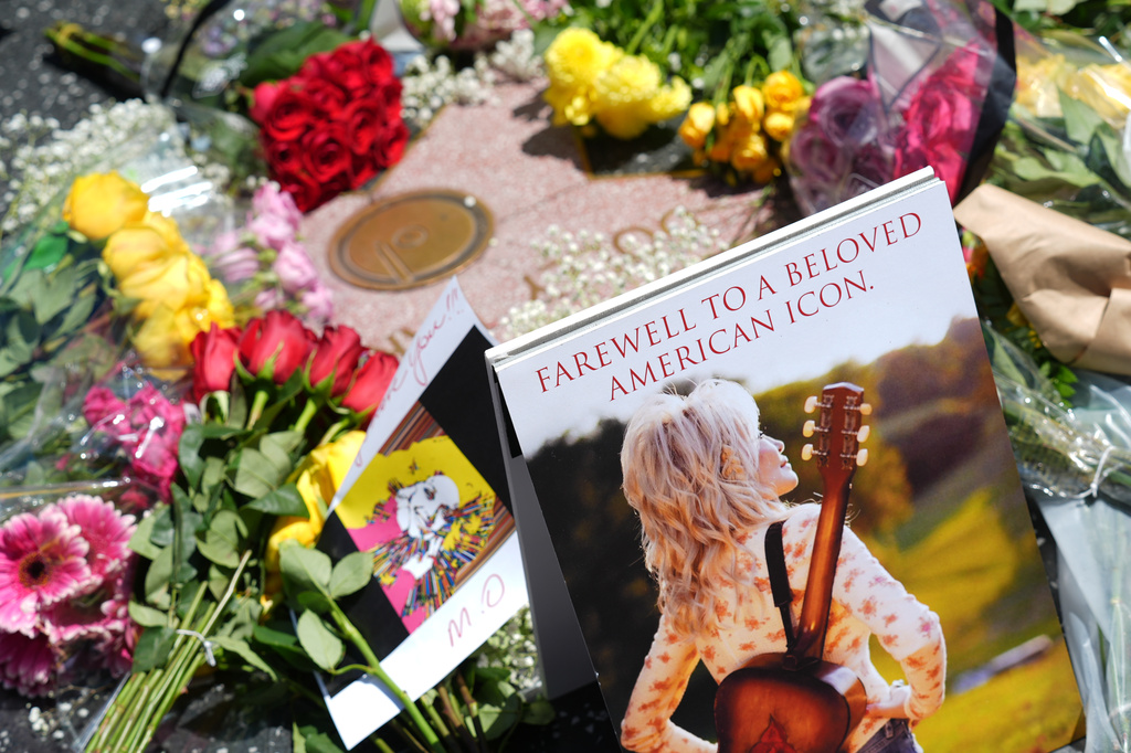 Dolly Parton's star on the Hollywood Walk of Fame is decorated with flowers Tuesday, Aug. 25, 2026, in Los Angeles. (AP Photo/Chris Pizzello)