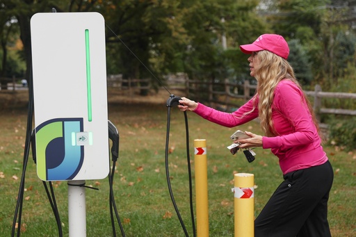 Daphne Dixon grabs part of a charger for her electric vehicle with a Level 2 EV charger, Saturday, Oct. 11, 2025, in Norwalk, Conn. (AP Photo/Heather Khalifa) Daphne Dixon grabs part of a charger for her electric vehicle with a Level 2 EV charger, Saturday, Oct. 11, 2025, in Norwalk, Conn. (AP Photo/Heather Khalifa)
