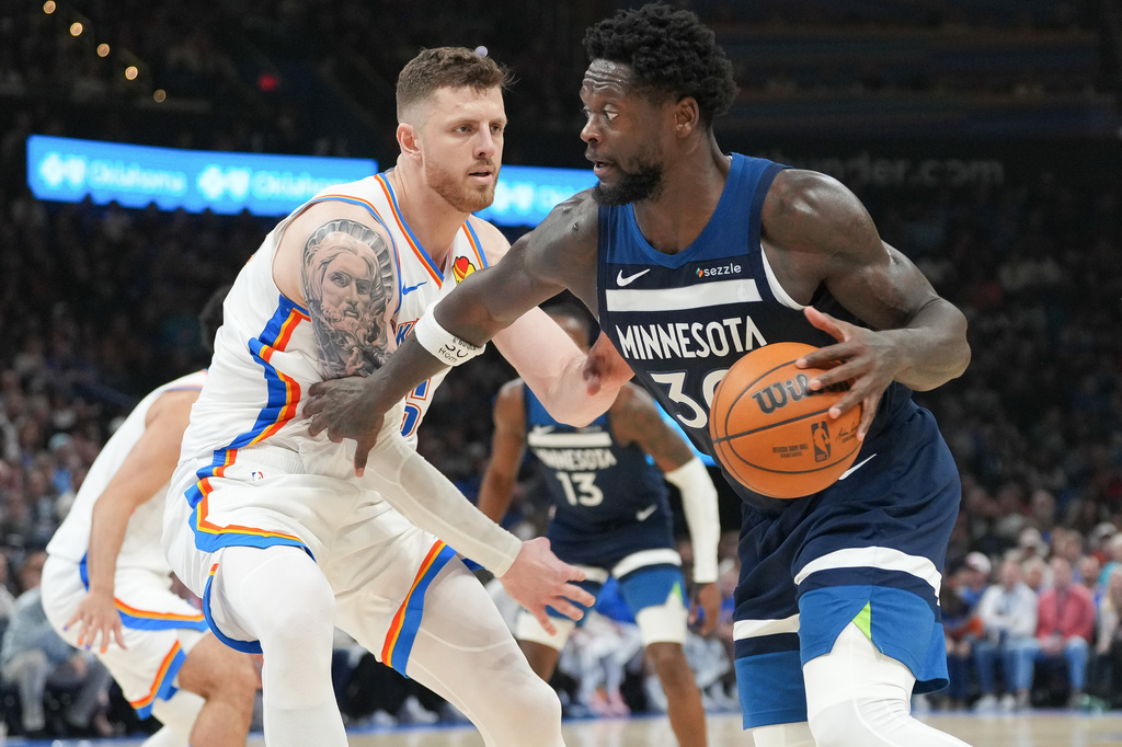 Minnesota Timberwolves forward Julius Randle, right, pushes past Oklahoma City Thunder center Isaiah Hartenstein, left, during the second half of an NBA basketball game, Sunday, March 15, 2026, in Oklahoma City. (AP Photo/Kyle Phillips)