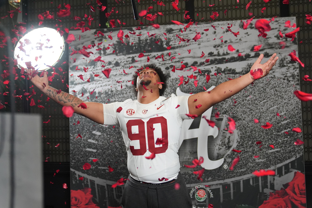 Alabama defensive lineman London Simmons (90) throws rose pedals in the air during a video shoot ahead of Thursday's Rose Bowl College Football Playoff against Indiana Tuesday, Dec. 30, 2025, in Los Angeles. (AP Photo/Marcio Jose Sanchez)