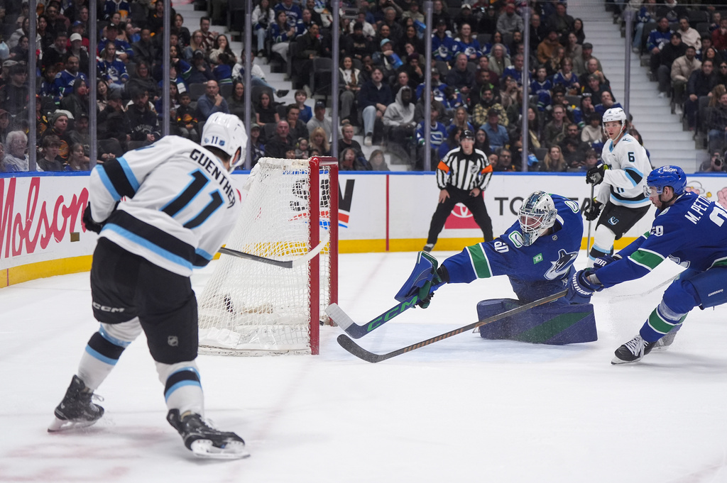 Utah Mammoth's Dylan Guenther (11) scores against Vancouver Canucks goalie Nikita Tolopilo (60) as Marcus Pettersson (29) defends during the second period of an NHL hockey game, in Vancouver, on Saturday, April 4, 2026. (Darryl Dyck/The Canadian Press via AP)