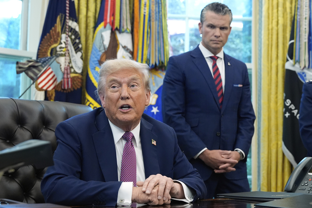 President Donald Trump speaks in the Oval Office of the White House, Friday, Sept. 5, 2025, in Washington, as Defense Secretary Pete Hegseth listens. (AP Photo/Alex Brandon)