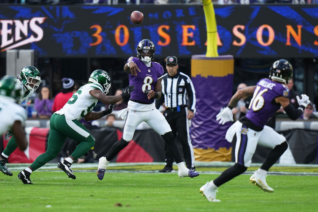 Baltimore Ravens quarterback Lamar Jackson (8) throws under pressure from New York Jets linebacker Quincy Williams (56) during the first half of an NFL football game, Sunday, Nov. 23, 2025, in Baltimore. (AP Photo/Stephanie Scarbrough)
