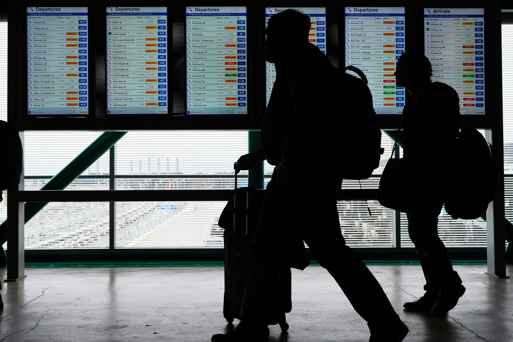 Travelers walk though the terminal at O'Hare International Airport, in Chicago, Sunday, Nov. 30, 2025. (AP Photo/Nam Y. Huh)