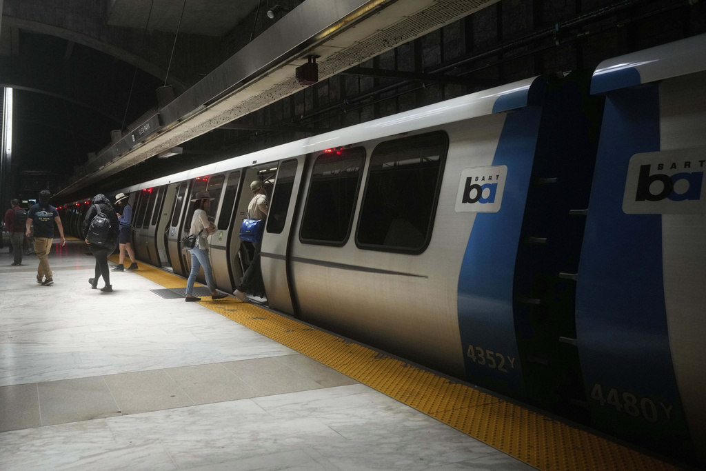 FILE - Passengers walk on and off a Bay Area Rapid Transit train at a BART station in San Francisco, Friday, May 9, 2025. (AP Photo/Jeff Chiu, File)
