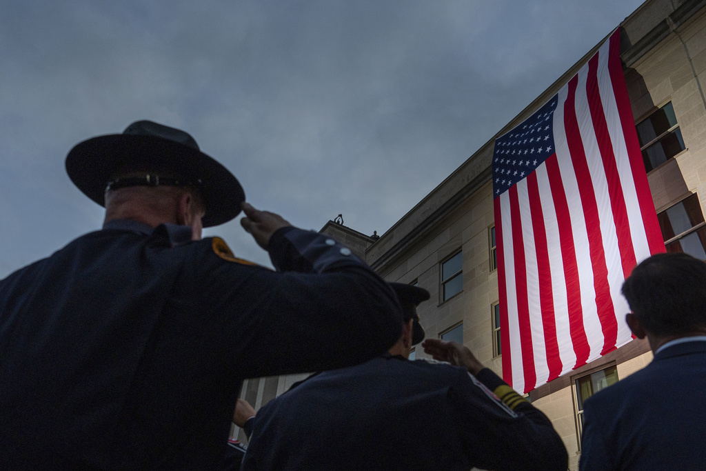 First responders salute as an American flag is unfurled from the top of the Pentagon at sunrise, Thursday, Sept. 11, 2025, in Washington. (AP Photo/Julia Demaree Nikhinson)