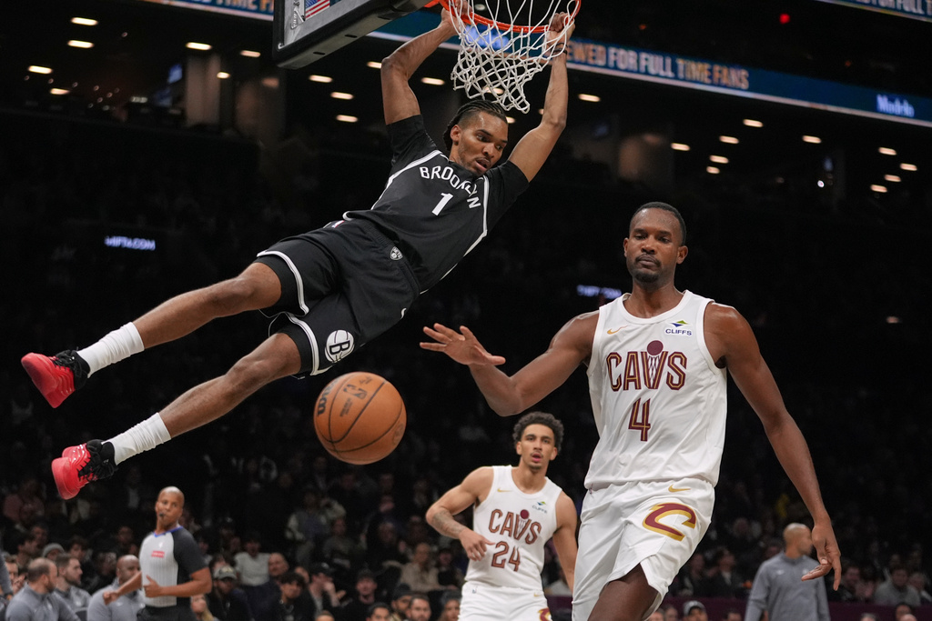 Brooklyn Nets' Ziaire Williams (1) dunks the ball in front of Cleveland Cavaliers' Evan Mobley (4) and Tyrese Proctor (24) during the second half of an NBA basketball game Friday, Oct. 24, 2025, at Barclays Center in New York. (AP Photo/Frank Franklin II)