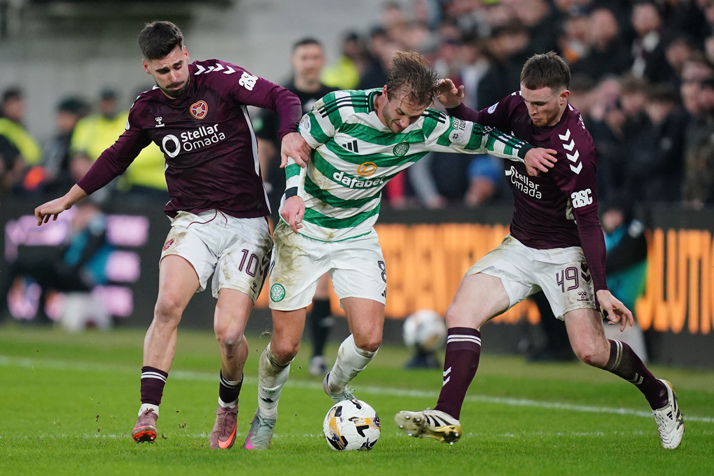 Celtic's Benjamin Nygren battles for the ball with Heart of Midlothian's Claudio Braga, left, and Marc Leonard during the William Hill Premiership match in Edinburgh, Scotland, Sunday Jan. 25, 2026. (Jane Barlow/PA via AP)