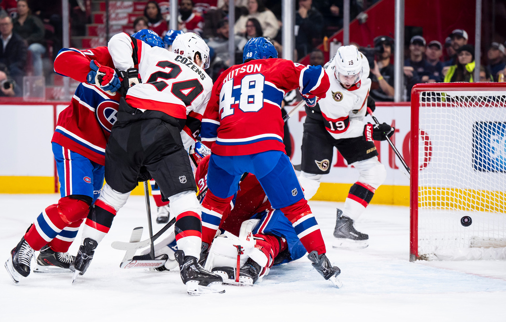 Ottawa Senators' Drake Batherson (19) scores on Montreal Canadiens' goaltender Sam Montembeault while Lane Hutson (48) defends and Ottawa Senators' Dylan Cozens (24) looks on during the second period NHL hockey game in Montreal, Tuesday, Dec. 2, 2025. (Christopher Katsarov/The Canadian Press via AP)
