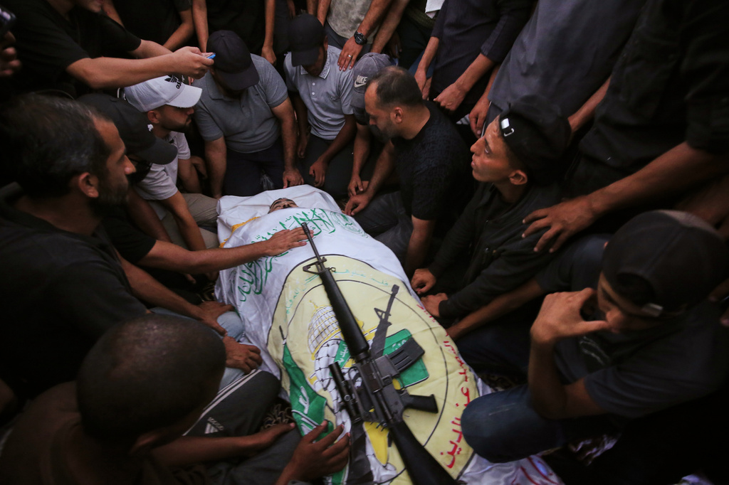 Palestinians mourn around the body of Nael Abu Obeid, a commander of the Qassam Brigades in Rafah, the military wing of Hamas, draped in the group's flag with a rifle placed on top, during his funeral after he was killed in an Israeli airstrike, in Khan Younis, Wednesday, Sept. 16, 2026. (AP Photo/Yousef Al Zanoun)