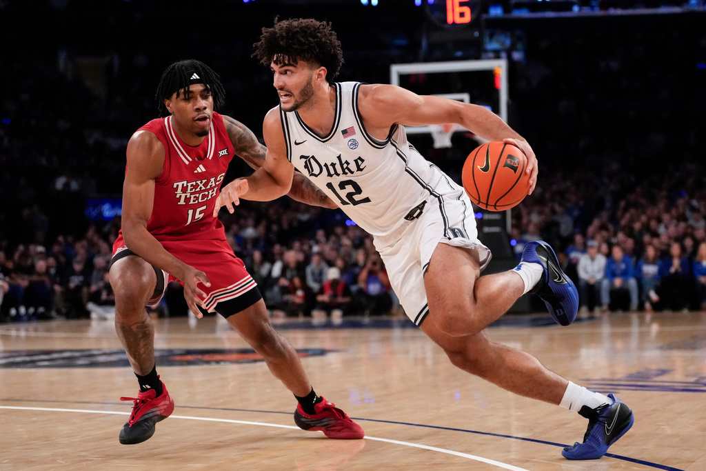Duke forward Cameron Boozer (12) drives past Texas Tech forward JT Toppin (15) during the first half of an NCAA college basketball game, Saturday, Dec. 20, 2025, in New York. (AP Photo/Yuki Iwamura)