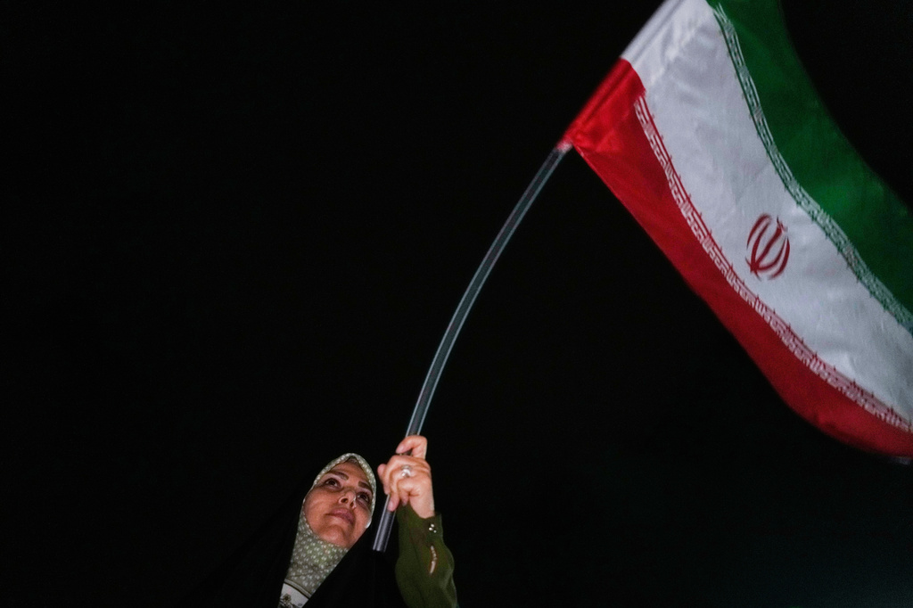 A demonstrator waves an Iranian flag in a pro-government gathering in Tehran, Iran, Sunday, June 7, 2026. (AP Photo/Vahid Salemi)