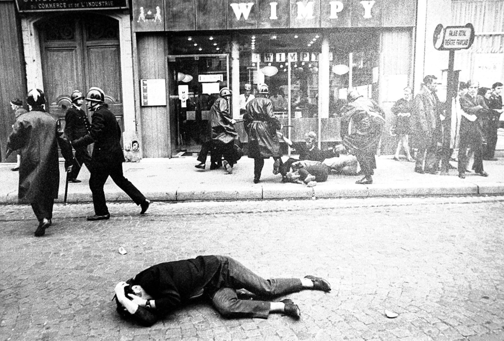 FILE - A demonstrator lies on the ground during clashes with police in Paris in May 1968 during the would-be student revolution. (AP Photo/Guy Kopelowicz, File)
