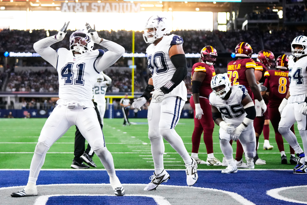 Dallas Cowboys defensive end Donovan Ezeiruaku (41), with defensive end Solomon Thomas (90) approaching, reacts after recording a sack against Washington Commanders quarterback Marcus Mariota (8) during the second half of an NFL football game Sunday, Oct. 19, 2025, in Arlington, Texas. (AP Photo/Jeffrey McWhorter)